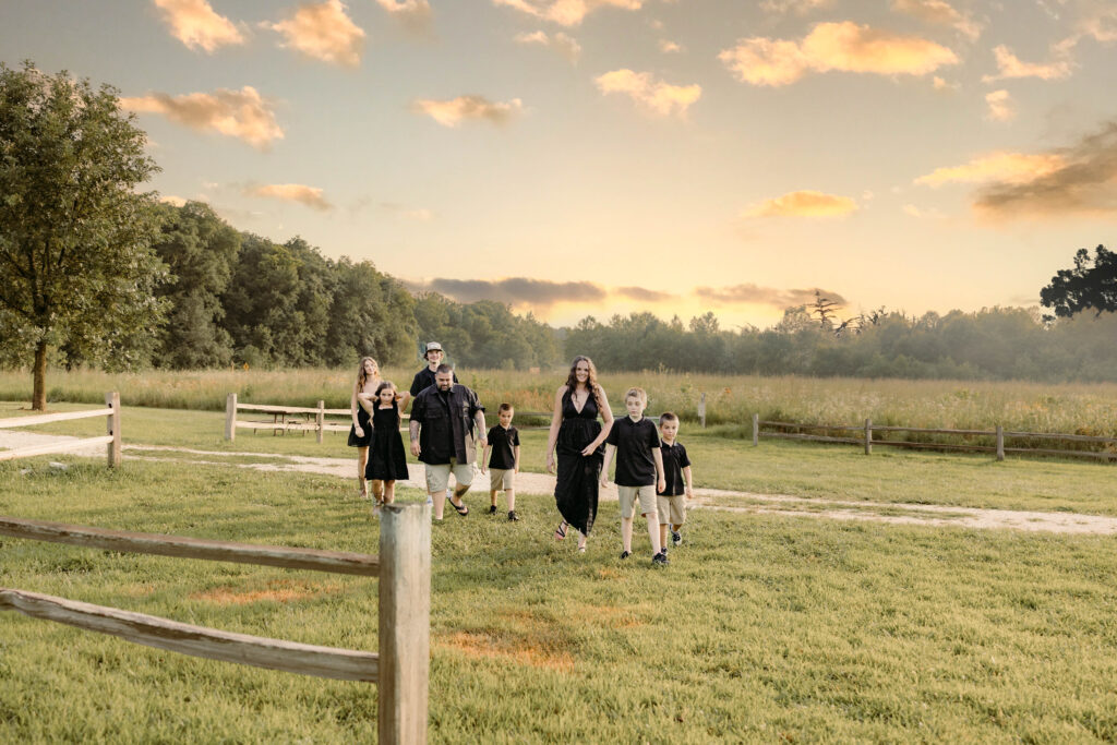 Large family walking through a field at golden hour western photoshoot