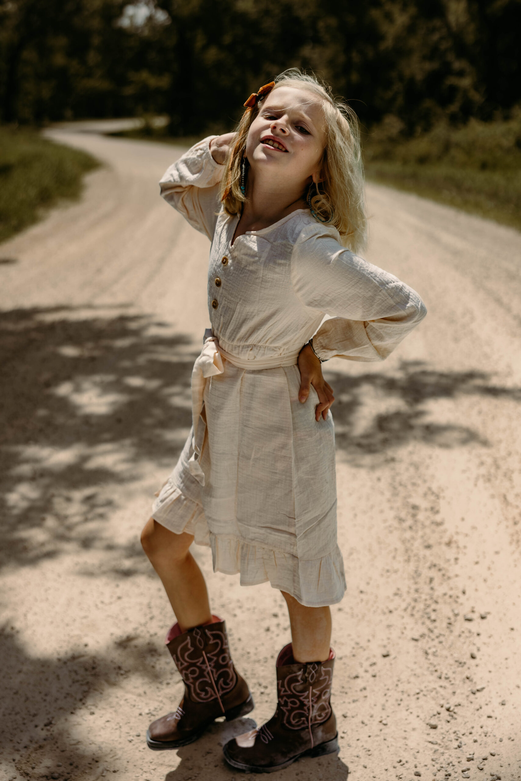 Young girl posed in boots and on a gravel road in rural Missouri